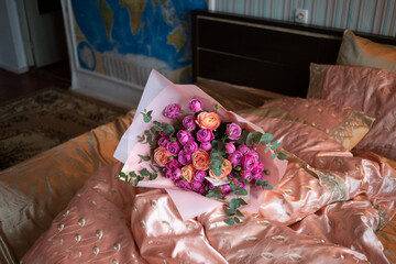 A large bouquet of roses lies on the spread bed in the interior.