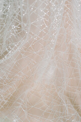 Spider web fabric texture. Pink and peach color. Hanging wedding dress of the bride.