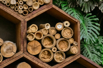 Fototapeta na wymiar Hexagonal wooden drawers that have several beehives made of bamboo inside.