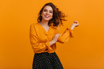 Front view of happy girl isolated on yellow background. Studio shot of blissful brunette woman in...