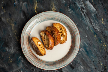 Italian cantuccini cookies. Macaroons on a plate on a dark background. Fitness food Rustic style.