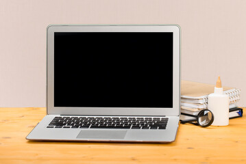 mocap Laptop with notebooks and office stuff on a wooden table.