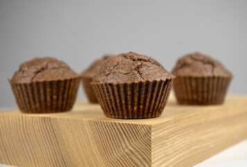 Brown chocolate muffins on wooden board