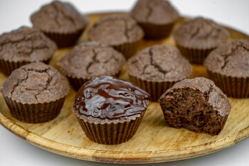 Set of homemade chocolate brown muffins on a wooden plate