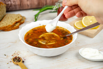 Traditional russian soup solyanka. Hodgepodge soup with meat, lemon and olives. Served with sour...