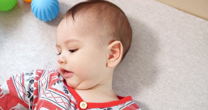 infant, childhood concept - close-up of smiling happy Baby plays with a teether. Teeth cutting. First teeth. Joy toothless 7 months baby bite, gnaws teether toy