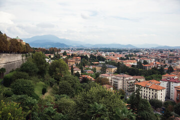 Fototapeta na wymiar Top view of houses, streets of old Italian city of Bergamo and mountains. Panorama of city.