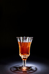 alcoholic drink in a glass with edges on a black background