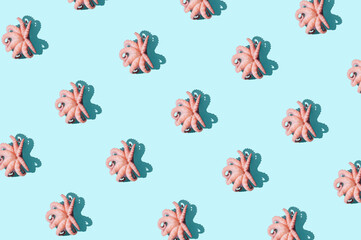 Creative pattern made with pink baby octopuses against vibrant  blue background. Minimal seafood summer concept. Isometric view.