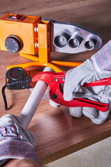 Soldering iron for polypropylene pipes next to polypropylene pipes and gloves