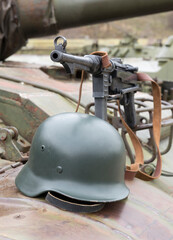 German  submachine gun and helmet on the armor of the tank