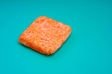 Orange bricks of frozen grated carrots. Procurement of frozen food. Semifinished
