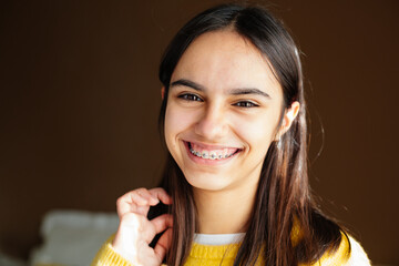 Cute and happy teen girl with braces smiling to camera