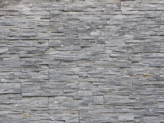 Wall with decorative gray embossed narrow tile cladding. Not seamless texture