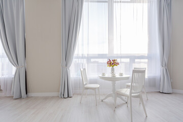 Luxurious and expensive interior of an open-plan apartment in light colors. Stylish modern bedroom with minimal design, dining area and guest space.