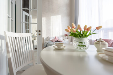 Luxurious and expensive interior of an open-plan apartment in light colors. Stylish modern bedroom with minimal design, dining area and guest space.