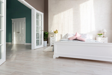 Stylish modern bedroom with a minimalistic design in a luxurious rich, expensive interior of an open-plan apartment in light colors.