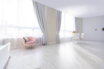 Luxurious and expensive interior of an open-plan apartment in light colors. Stylish modern bedroom with minimal design, dining area and guest space.