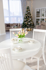 Luxury rich expensive apartment interior in light colors. Stylish contemporary minimalistic design. Full of sun light. A lot of space decorated with Christmas tree