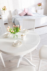 Luxurious and expensive interior of an open-plan apartment in light colors. Stylish modern bedroom with minimal design, dining area and guest space.