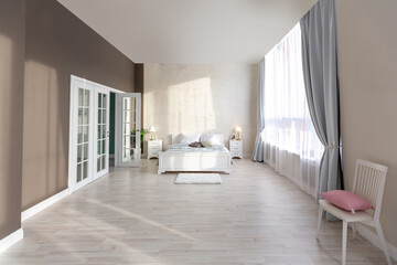 Fototapeta na wymiar Stylish modern bedroom with a minimalistic design in a luxurious rich, expensive interior of an open-plan apartment in light colors.