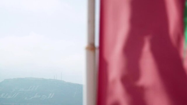 Reveal Shot Of Morocco National Flag Waving In The Wind At Agadir Beach In Morocco - close up