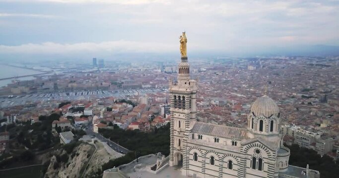 The Scenic Stone Bell Tower Of Notre Dame De La Garde Basilica In Marseille, France - aerial pullback