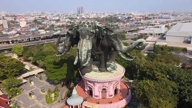 4k Cinematic Aerial footage of Erawan museum in Samut Prakan Province, Bangkok, Thailand. Drone pans backwards at a three-headed elephant statue. Hindu gods. Ganesha. Megapolis Cityscape