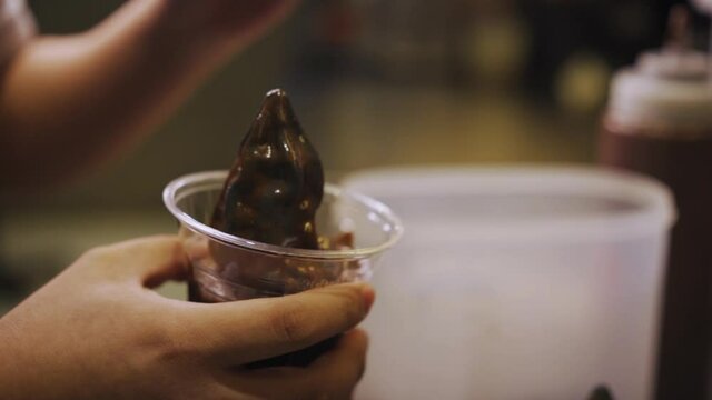 Worker In Cafe Put Toppings On Chocolate Sundae. - close up