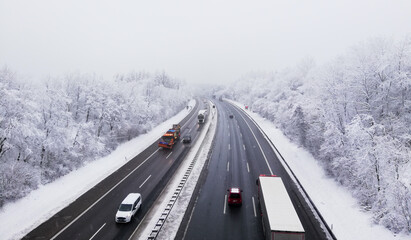 car driving on the highway in winter forest