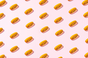 Creative pattern fish oil tablet on light pink background.