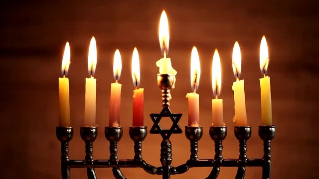 Menorah with burning candles for Hanukkah on dark background