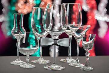 Alcohol glasses with bow tie isolated on colourful background. International Bartenders Day