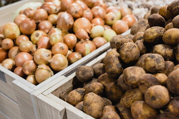 Potatoes and onions on blurred background in supermarket
