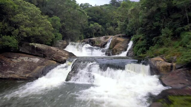 Aerial drone footage of waterfall in national park in Brazil. Parque Estadual Serra do Mar, with Atlantic forest and big trees. Mountain river flowing through rocks ans stones.
