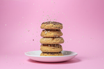 Shortbread cookies on a pink background. Shortbread cookies with sprinkles on a white plate. Sprinkle with sesame seeds. Light dessert