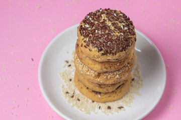 Shortbread cookies on a pink background. Shortbread cookies with sprinkles on a white plate. Light dessert