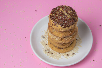 Shortbread cookies on a pink background. Shortbread cookies with sprinkles on a white plate. Light dessert