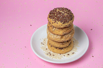 Shortbread cookies on a pink background. Shortbread cookies with sprinkles on a white plate. Light dessert