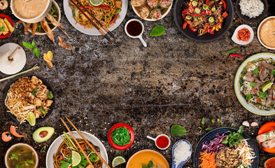 Asian food served on black stone table, top view, space for text. Chinese and vietnamese cuisine...