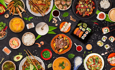 Asian food served on black stone table, top view, space for text. Chinese and vietnamese cuisine set.
