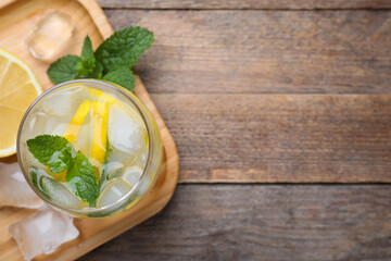 Delicious lemonade made with soda water and fresh mint on wooden table, top view. Space for text
