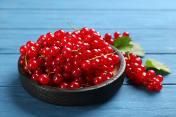Delicious red currants on blue wooden table
