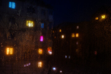 Fototapeta na wymiar Water drops reflections on the window in night