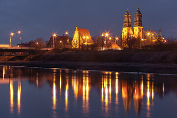 Poznan Cathedral, Archcathedral Basilica of St Peter and St Paul at night with reflection in Warta River, Poznan, Poland