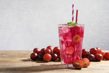 Delicious grape soda water with mint and berries on wooden table. Refreshing drink