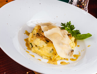 Mashed potatoes with seafood and cheese on white plate