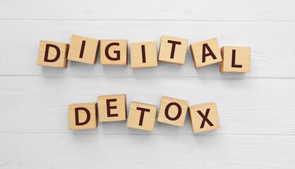 Cubes with phrase DIGITAL DETOX on white wooden table, flat lay