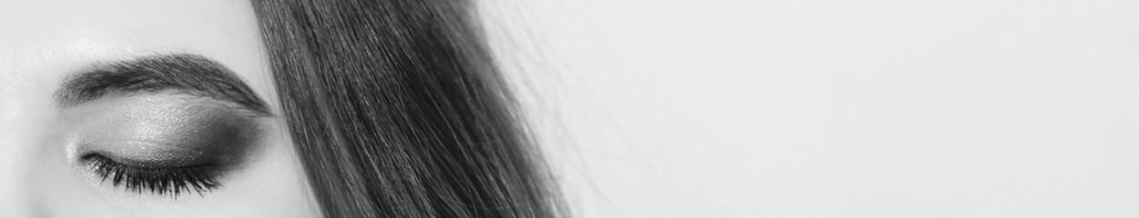 Beautiful macro shot of female eye. Closeup macro shot of fashion eyes visage. Banner size. Black and white.