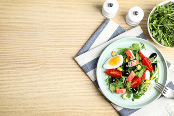 Tasty crab stick salad served on wooden table, flat lay. Space for text